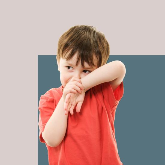 Foto af dreng, der er genert og holder sine hænder op foran hovedet