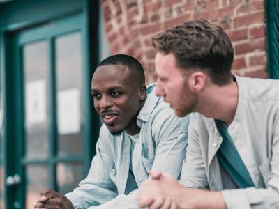 Foto af to mænd, der taler sammen udenfor