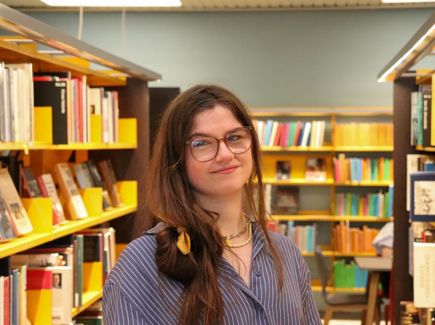 Billede af Maja Mijatovic, bibliotekar. Maja har langt mørkt hår og store briller.