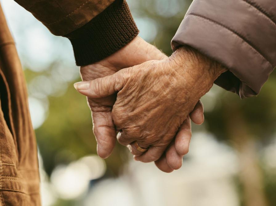 To ældre holder hinanden i hånden